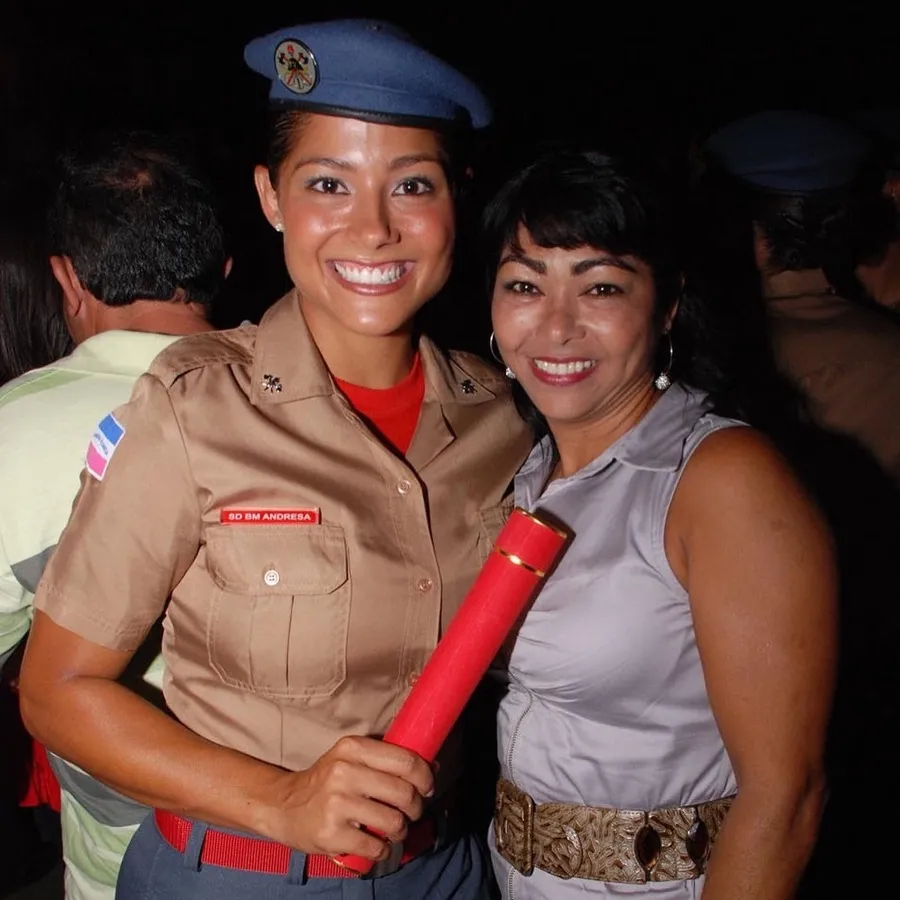 Andresa recém-formada soldado, de boina, abraçada com a mãe na noite da formatura.